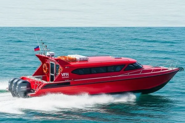 Red fibreglass crew boat running at speed on open water off Port Klang
